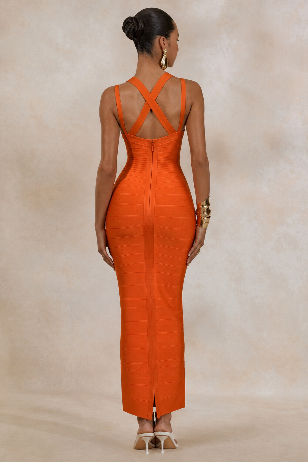 Woman wearing an orange from allure dress with a beige background