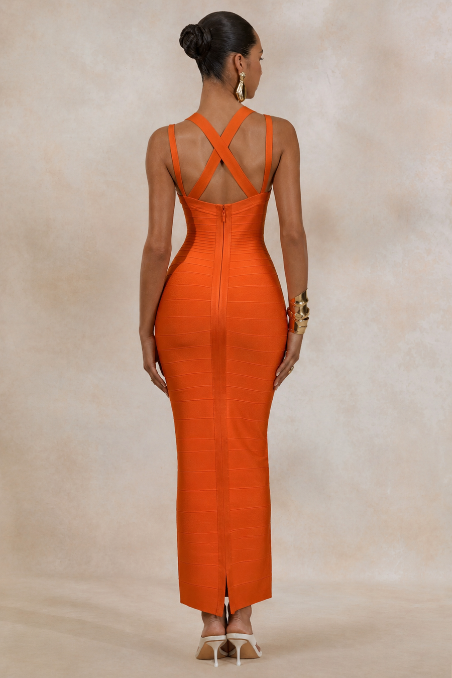 Woman wearing an orange from allure dress with a beige background