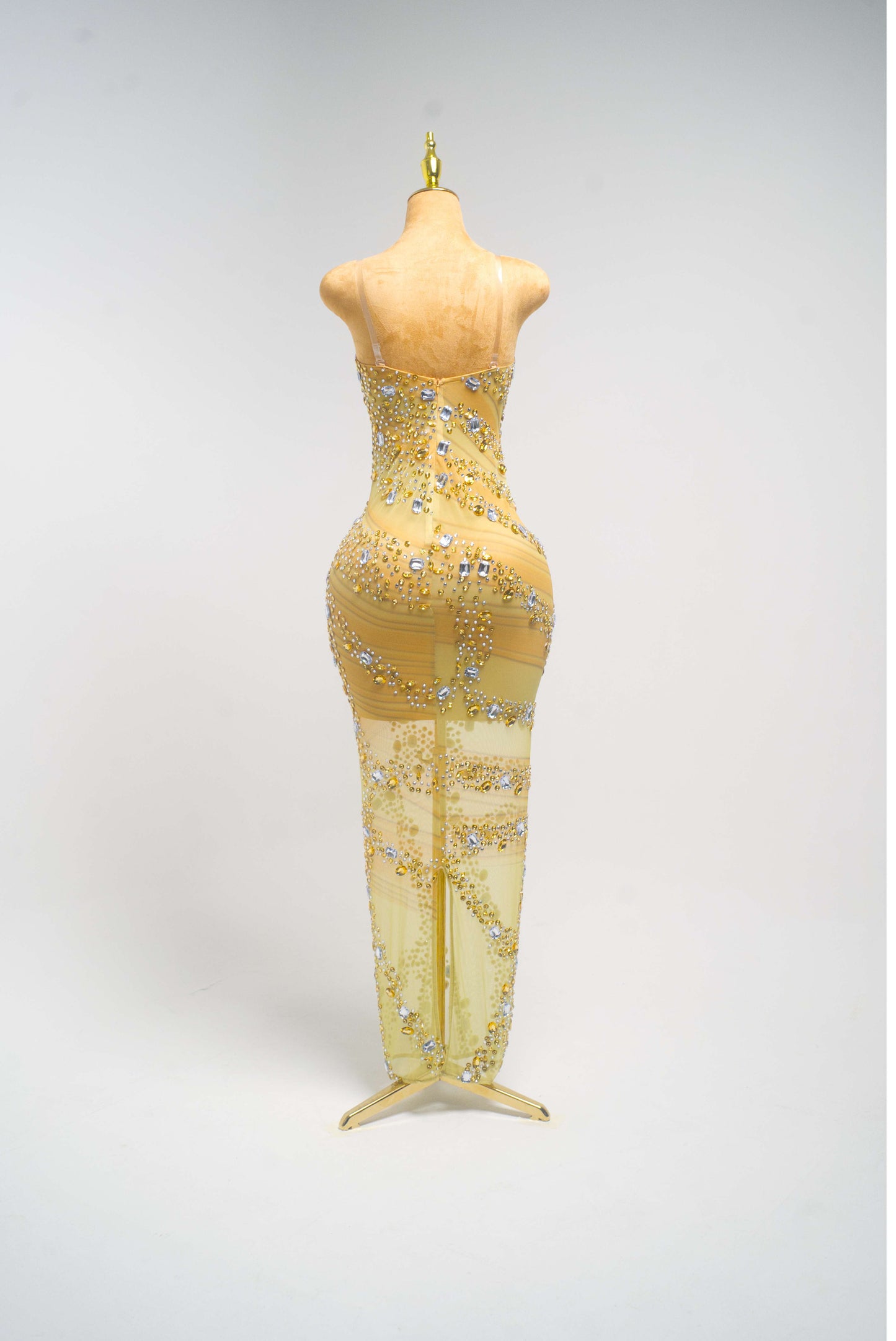 gold from allure evening gown with beading on a mannequin against a gray background