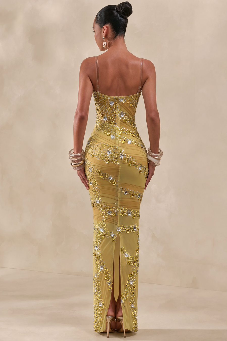 Woman wearing a  from allure gold beaded evening gown against a beige background
